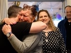 Ofer Kalderon's family embrace each other at their home in Kfar Saba as they heard the new of his release from Hamas' captivity in the Gaza Strip. Kalderon was handed over to the Red Cross before the released Israeli hostages were able to see their families.(AFP)